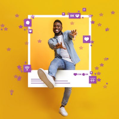 Positive African American guy dancing and jumping out of photo frame over yellow studio background, collage with social media reactions. Concept of blogging and SMM marketing
